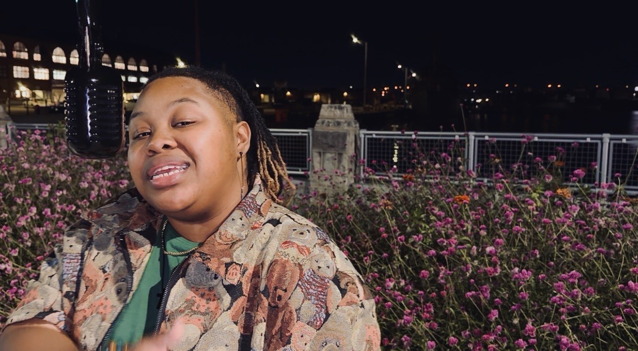 CreNaetive smiling at the microphone outdoors at night